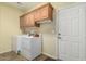 Functional laundry room with washer, dryer, and storage cabinets above at 11056 E Nopal Ave, Mesa, AZ 85209