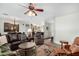 Bright living room with a leather sofa, ceiling fan, and open view of the kitchen at 11056 E Nopal Ave, Mesa, AZ 85209