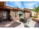 Inviting outdoor patio with a dining table, lush landscaping, and stone accents at 11056 E Nopal Ave, Mesa, AZ 85209