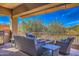 Outdoor living space with built-in grill, fire pit, and comfortable seating with desert views at 11656 N 135Th Pl, Scottsdale, AZ 85259