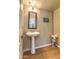 Bathroom features hardwood floors, a white pedestal sink, and a decorative mirror at 11656 N 135Th Pl, Scottsdale, AZ 85259