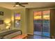 Relaxing bedroom featuring a ceiling fan, warm lighting, and scenic sunset views from the window and sliding glass doors at 11656 N 135Th Pl, Scottsdale, AZ 85259