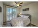 Bright bedroom featuring a cozy bed, natural light from a sliding door, and charming decor at 11656 N 135Th Pl, Scottsdale, AZ 85259