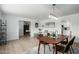 Open-concept dining room with modern lighting, light wood floors, and views to other living spaces at 1206 E Loyola Dr, Tempe, AZ 85282