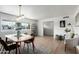 Bright dining room featuring a modern light fixture, white walls, and light wood flooring at 1206 E Loyola Dr, Tempe, AZ 85282