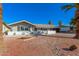 Charming single-story home features a low white brick wall, desert landscaping and mature palm trees at 1206 E Loyola Dr, Tempe, AZ 85282