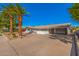 Charming single-story home features a low white brick wall, mature palm trees and desert landscaping at 1206 E Loyola Dr, Tempe, AZ 85282