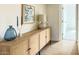 Hallway featuring modern wood cabinet and decor with tiled floors leading to a bright, open doorway at 1206 E Loyola Dr, Tempe, AZ 85282