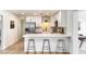 Well-lit kitchen featuring white cabinets, stainless steel appliances, a breakfast bar, and wood-look floors at 1206 E Loyola Dr, Tempe, AZ 85282