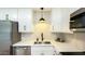 Close-up of the kitchen with sleek countertops, white cabinets, black hardware, and stylish pendant lighting at 1206 E Loyola Dr, Tempe, AZ 85282