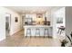 Modern kitchen featuring white cabinets, stainless steel appliances, a breakfast bar, and wood-look floors at 1206 E Loyola Dr, Tempe, AZ 85282