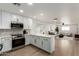 Open floor plan with a kitchen featuring white cabinets and stainless steel appliances connected to living room at 1206 E Loyola Dr, Tempe, AZ 85282