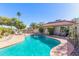 Sparkling pool with lush landscaping and lounge chairs in a private backyard oasis at 12601 S Tonto Ct, Phoenix, AZ 85044