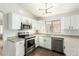 Bright kitchen showcasing white cabinetry, stainless steel appliances, granite countertops, and modern lighting fixtures at 13267 W Port Au Prince Ln, Surprise, AZ 85379