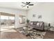 Inviting living room with tile floors, neutral walls, large windows, ceiling fan, and sliding glass door at 13267 W Port Au Prince Ln, Surprise, AZ 85379