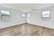 Bright, open bedroom with wood-look tile floors, white walls, recessed lighting, and multiple windows at 13386 W Eagle Feather Rd, Peoria, AZ 85383