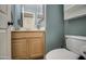 Powder room with wood vanity, mirror, and toilet, showcasing clean and simple design at 13556 W Desert Flower Dr, Goodyear, AZ 85395