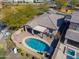 Aerial view of a backyard oasis with a pool, covered patio, outdoor dining, and lush greenery for entertainment at 139 E Desert Broom Dr, Chandler, AZ 85286