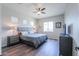 Cozy bedroom with a ceiling fan, wood-look floors, neutral tones, and a comfortable queen-size bed at 139 E Desert Broom Dr, Chandler, AZ 85286