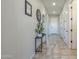 Inviting hallway with tiled floors, neutral walls, and decorative art leading to the front door at 139 E Desert Broom Dr, Chandler, AZ 85286