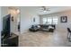 Comfortable living room with a modern sectional sofa, a ceiling fan, and large windows for natural light at 139 E Desert Broom Dr, Chandler, AZ 85286