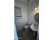 Powder room featuring neutral tile floors, a pedestal sink, toilet and window for natural light at 14334 W Avalon Dr, Goodyear, AZ 85395