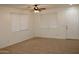 Bright living room features tile floors, a ceiling fan, and light-filled windows with white blinds at 14334 W Avalon Dr, Goodyear, AZ 85395