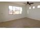 Simple living room features neutral tile flooring, a large window, and ceiling fan at 14334 W Avalon Dr, Goodyear, AZ 85395