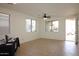 Bright living room features neutral tile flooring, multiple windows, and an open front door at 14334 W Avalon Dr, Goodyear, AZ 85395