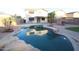 Inviting backyard with a refreshing pool, stone accents, and mature palm trees at 14334 W Avalon Dr, Goodyear, AZ 85395