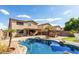 Inviting backyard oasis with sparkling pool, lush landscaping, and outdoor entertaining area at 14334 W Avalon Dr, Goodyear, AZ 85395