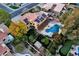 Aerial view of a landscaped backyard featuring a pool, covered patio, putting green, and mature trees at 15011 N 45Th Pl, Phoenix, AZ 85032