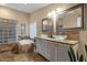 Bathroom featuring double vanity sinks, glass block shower, and separate tub at 15011 N 45Th Pl, Phoenix, AZ 85032