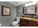 Powder bathroom featuring vanity with a stone countertop, stylish fixtures, and framed artwork at 15011 N 45Th Pl, Phoenix, AZ 85032