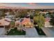 Inviting two-story home featuring a manicured lawn, desert landscaping, long driveway, solar panels, and a basketball hoop at 15011 N 45Th Pl, Phoenix, AZ 85032