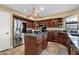 Open kitchen with stainless steel refrigerator, large granite island, and custom cabinets at 15011 N 45Th Pl, Phoenix, AZ 85032