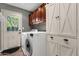 Functional laundry room with white appliances, custom cabinets, and tile flooring at 15011 N 45Th Pl, Phoenix, AZ 85032