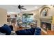 Comfortable living room with a ceiling fan, fireplace, and a view into the eat-in kitchen at 15011 N 45Th Pl, Phoenix, AZ 85032