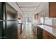 Galley kitchen with wood cabinets and black appliances with tile floors at 15652 N 52Nd St, Scottsdale, AZ 85254