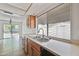 Well-lit kitchen featuring stainless steel sink, wooden cabinets, neutral countertop, and a window at 15652 N 52Nd St, Scottsdale, AZ 85254