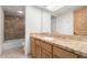 Bathroom featuring wood cabinets with granite countertop, stylish mirror and wood-framed door at 15843 E Mustang Dr, Fountain Hills, AZ 85268