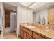 Well-lit bathroom featuring a spacious countertop, a sink, a large mirror, and tiled shower with curtain at 15843 E Mustang Dr, Fountain Hills, AZ 85268