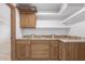 Kitchenette area with wooden cabinets, stone countertops, and white shelving at 15843 E Mustang Dr, Fountain Hills, AZ 85268
