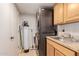 Practical laundry room with stacked washer/dryer, utility sink, and cabinet for efficient chores at 15843 E Mustang Dr, Fountain Hills, AZ 85268