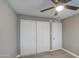 This bedroom features neutral walls, wood-look floors, a ceiling fan, and a large closet at 1630 N 58Th Ave, Phoenix, AZ 85035