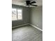 Bedroom features a ceiling fan, gray walls, wood-look flooring, and a large window at 1630 N 58Th Ave, Phoenix, AZ 85035