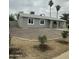 Charming single-story home with gray stucco, rock landscaping, and arched entryway at 1630 N 58Th Ave, Phoenix, AZ 85035