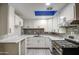 Renovated kitchen featuring white cabinets, marbled countertops, and stainless steel appliances at 1630 N 58Th Ave, Phoenix, AZ 85035