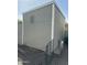 Side view of the outdoor storage shed with light gray walls, white trim, and a ventilation slot at 1630 N 58Th Ave, Phoenix, AZ 85035