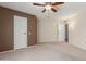 Carpeted bedroom with ceiling fan and access to bathroom at 17247 N 106Th Ave, Sun City, AZ 85373